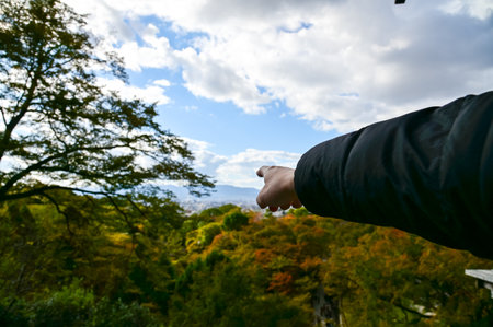 A man is pointing to the Kyoto city from kiyomizu-dera temple in Kyoto, Japan. Major tourist attraction in Kansai region in Japan. Travel concept. Japan cityscape.の写真素材