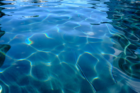 Close-up of the water of a swimming pool with the sunlight reflection. The scene of the swimming...