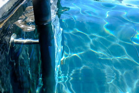 Close-up of the water of a swimming pool with the sunlight reflection. The scene of the swimming...