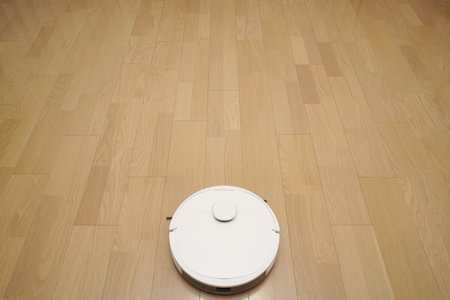 Robotic vacuum cleaner on laminate floor in living room. Smart home automation system.の写真素材
