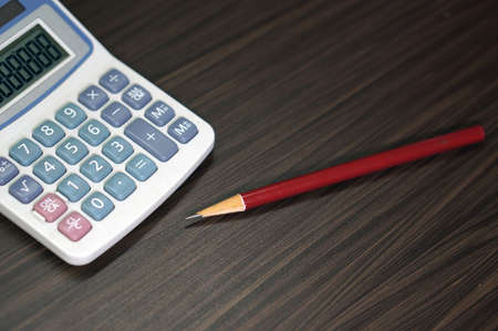 A Calculator and Pencil on wooden tableの写真素材