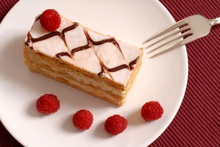 Pastry cream Napoleon with raspberries on white plate