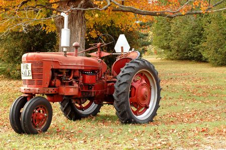 Red antique tractor in rural setting with autumn colorsの写真素材