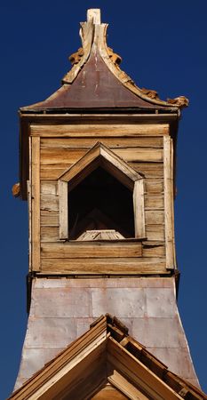 Old weathered wooden church steeple against a deep blue skyの写真素材