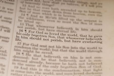 Old bible showing the biblical verse of John 3:16 with surrounding verses blurredの写真素材