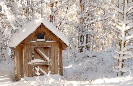 A snow bound wooden shack in a wooded settingの写真素材