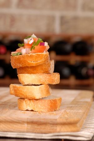 A stack of bruschetta with wine rack in backgroundの写真素材