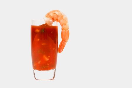A large shrimp on a glass containing cocktail sauce isolated on whiteの写真素材