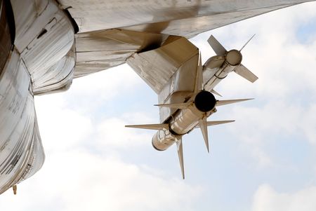 Two sidewinder rockets attached to the wing of a jet plane