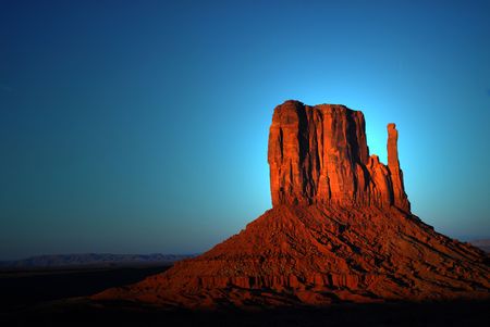 Dramatic light of dawn striking a rock formation in the Navajo nation land of Monument Valleyの写真素材