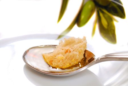 Piece of crusty bread resting in a spoonful of olive oilの写真素材