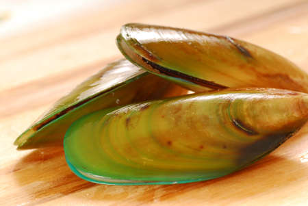 Fresh raw New Zealand green-lip mussels on a cutting boardの写真素材