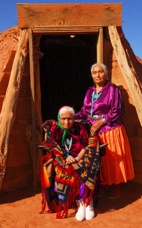 Elderly 99 year old Navajo Native American woman and her daughter standing in front of a traditional Hoganの写真素材
