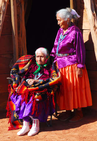 99 year old Navajo woman with her daughter in front of a traditional Hogan dwellingの写真素材