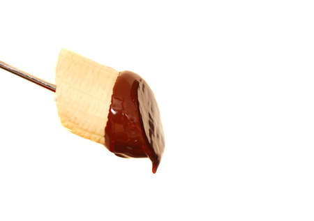 Fresh banana with dark chocolate sauce dripping from itの写真素材