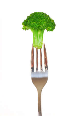 Fresh green broccoli on the end of a forkの写真素材