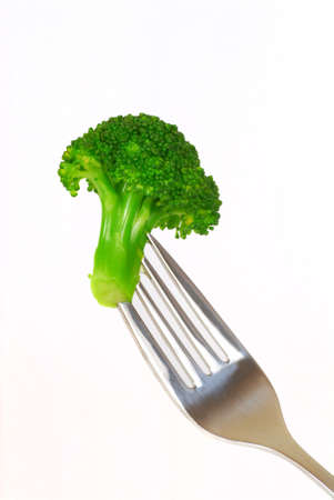 Fresh green broccoli on the end of a forkの写真素材