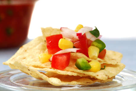 Freshly made tortilla chips with a corn and tomato salsaの写真素材