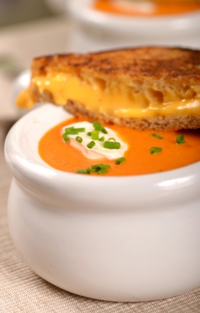 Delicious bowl of homemade tomato soup with a grilled cheese sandwichの写真素材