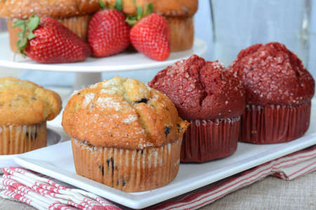 Variety of delicious breakfast muffins served on platters with strawberriesの写真素材