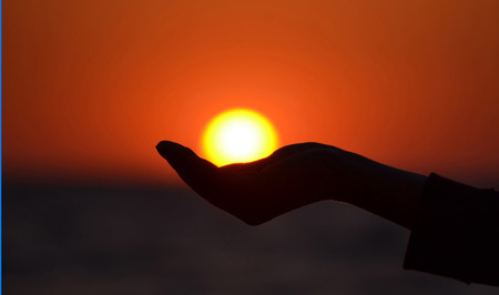 Close up of woman hand holding sun in handの写真素材