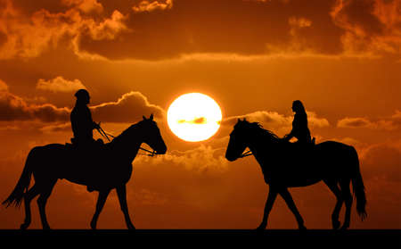 Silhouette of two riders on sunsetの写真素材