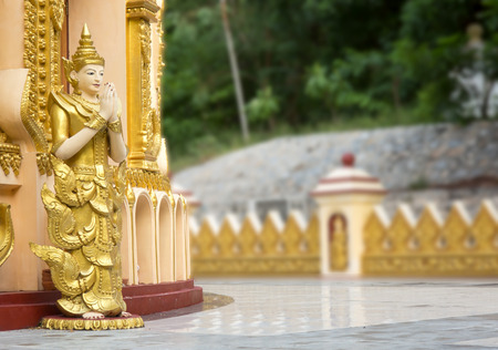 Statue of an angel standing in front of a pagodaの写真素材