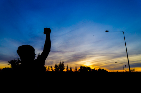 Men raise their hands in the sunriseの写真素材