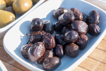 Black olives on a white plateの写真素材