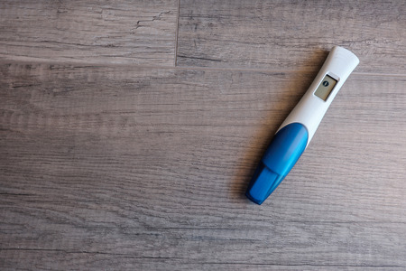 Digital pregnancy test with negative result on wooden background