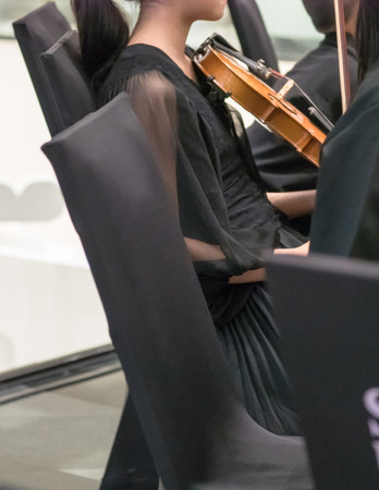 Woman wearing black, performing violin in a bandの写真素材