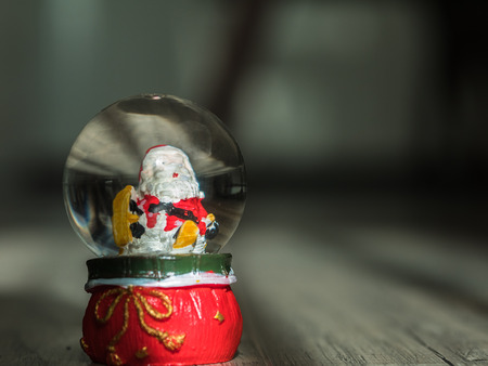 Christmas background with santa doll in a ball on wooden floorの写真素材