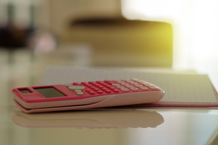 Pink calculator on a blank notebook on an officeの写真素材