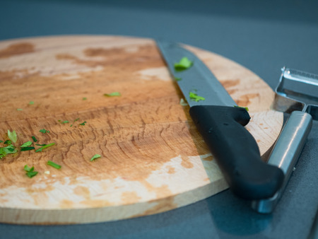 Wooden cutting board with knife after preparing green leafの写真素材