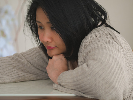 Woman sitting and reading a book on a table