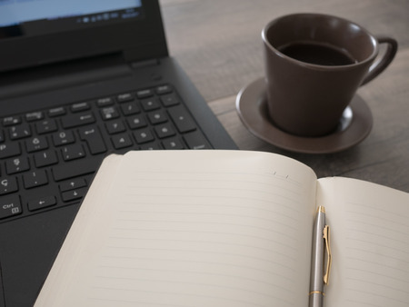 Open notebook with laptop, flower and coffee, working concept