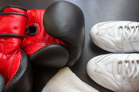 Boxing shoes, gloves and towel on black backgroundの写真素材