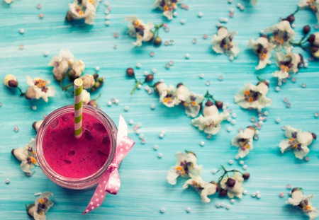 Strawberry smoothie on blue background with flowersの写真素材