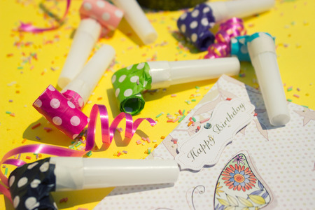 Party horns (whistles) and happy birthday card on yellow backgroundの写真素材