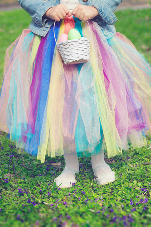 Little girl in the park, holding easter egg and basketの写真素材