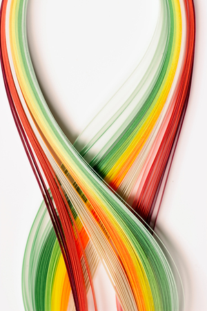 Yellow, green, orange and red paper stripes on white background; abstract lines backgroundの写真素材