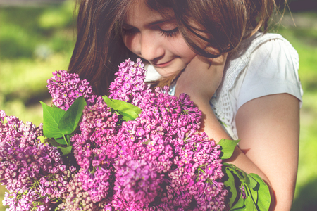 Little girl with bouquet of lilac in her handsの写真素材