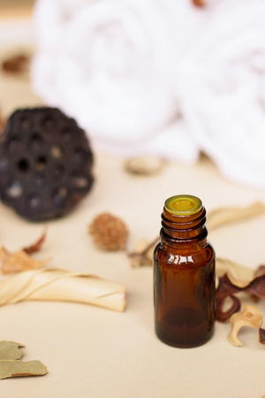 Essential oil and dry flowers on beige backgroundの写真素材