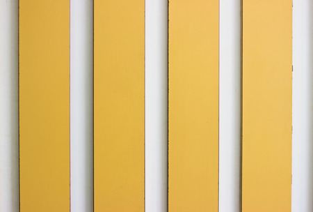 Decorative yellow and white stripe panels on the wallの写真素材