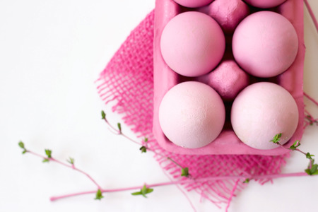 Pink easter eggs in pink box with decoration, on white background with copy space; easter wallpaperの写真素材