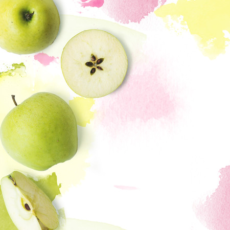 Fresh green apples on white background with watercolor strokes; creative layout with copy spaceの写真素材