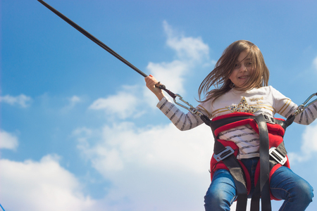 Little girl jumping on trampolineの写真素材