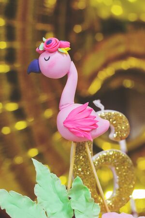 Flamingo topper - flamingo decoration and number six candle on a birthday cakeの写真素材