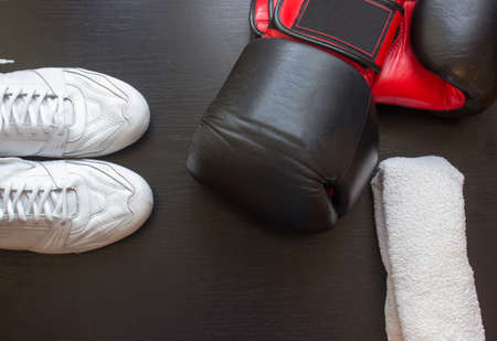 Boxing shoes, gloves and towel on black backgroundの写真素材
