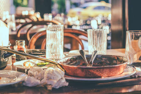 Leftovers, empty plates and dirty glasses and dishes in restaurant after dinner